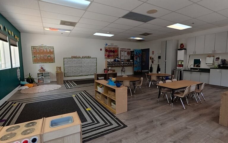 Preschool classroom with play kitchen and reading corner