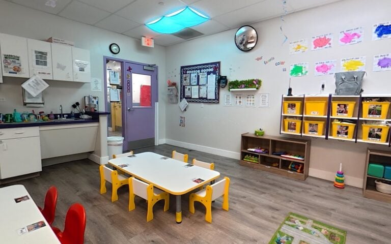 Toddler classroom with small tables and learning centers at Kids Inc.